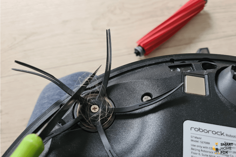 Волосы, намотанные на боковую щетку Roborock S7 MaxV Ultra, отрезают ножом